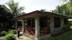 A stone building with a red roof and a porch with red railings. - Korovou Eco Resort (Naviti Island)