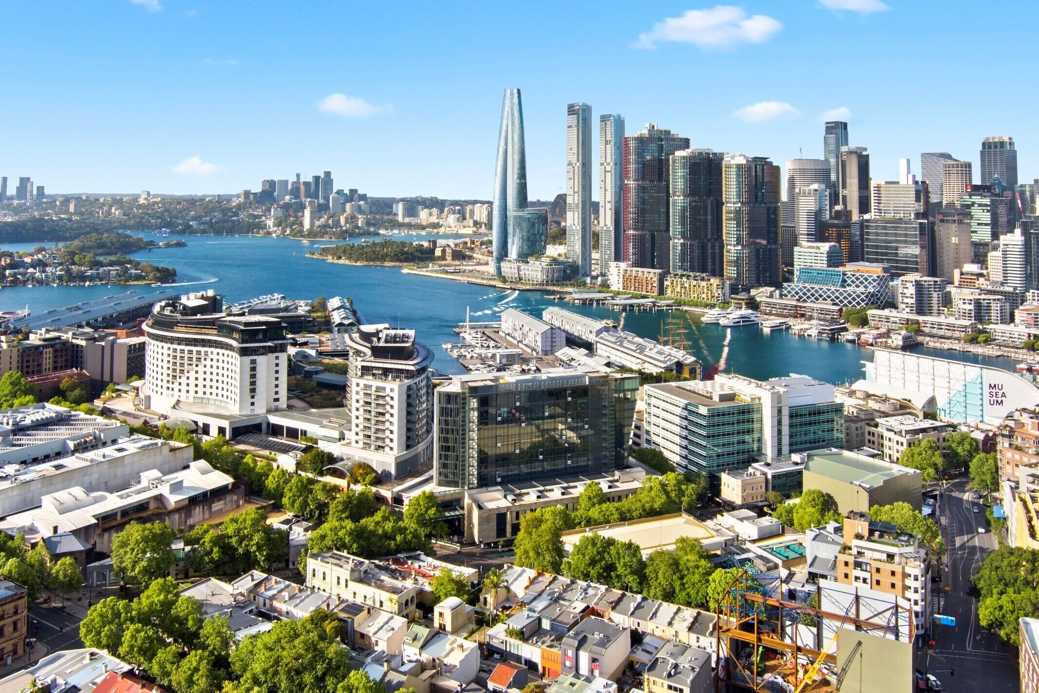 A cityscape with modern buildings, a waterfront, and a prominent museum.