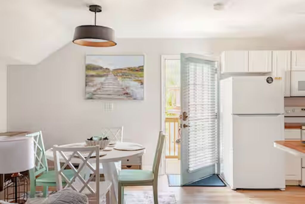A modern kitchen with white cabinets, a built-in oven, and a refrigerator.