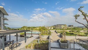 Une terrasse sur le toit avec des sièges extérieurs, une piscine et une vue sur le paysage urbain.
