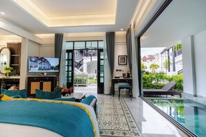 A modern hotel room with a large bed, a desk, a TV, and a balcony with a pool view. - Siri Villa Chiang Mai (Chiang Mai)