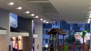 Zona de juegos interior con tobogán, columpios y estructura para escalar.