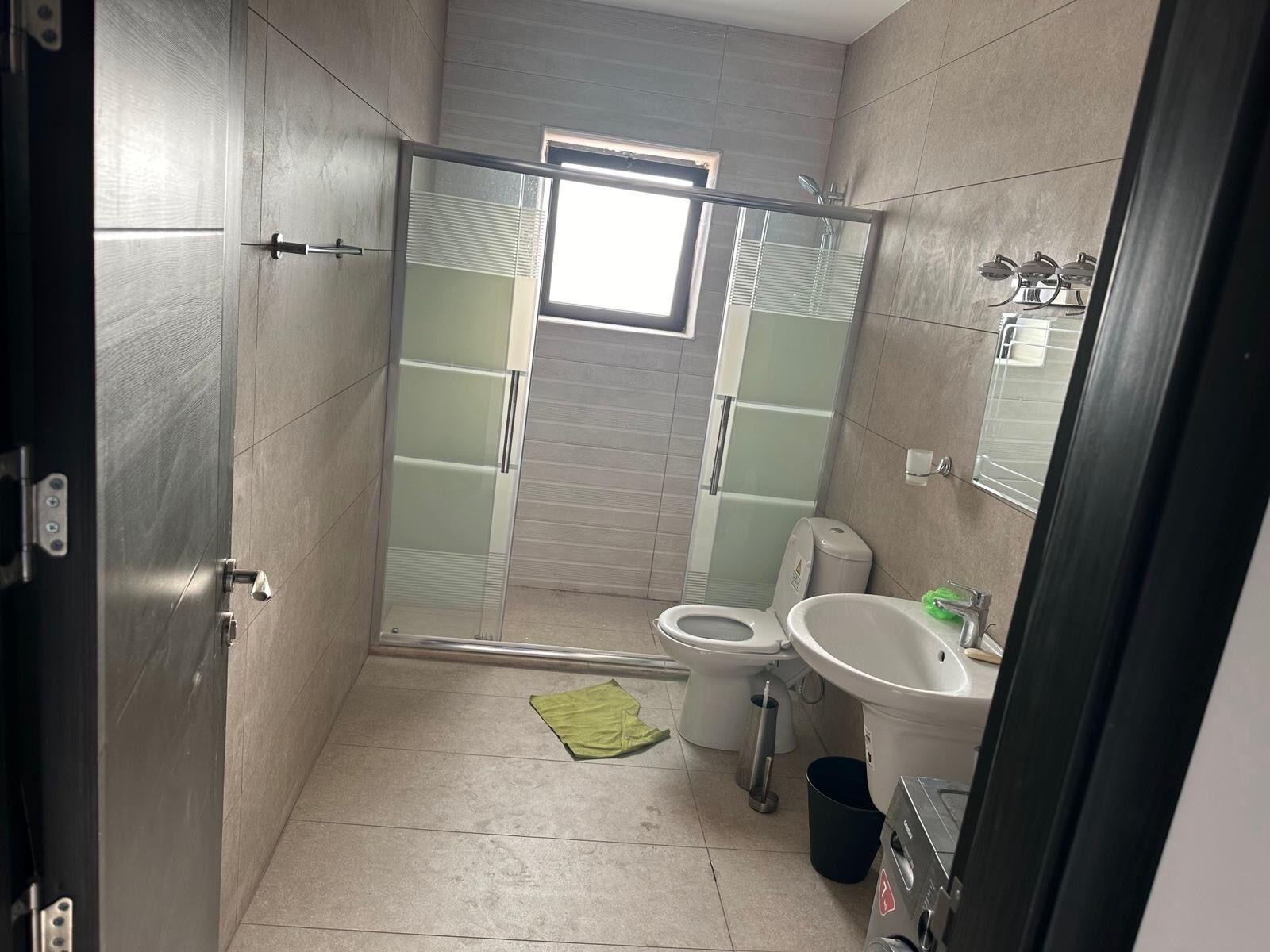 Un baño moderno con cabina de ducha de vidrio, un inodoro y un lavabo.