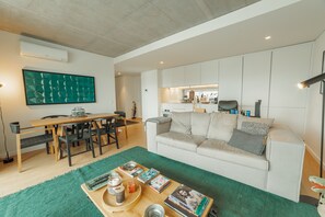 Un salon moderne avec un canapé, une table basse et un coin repas.