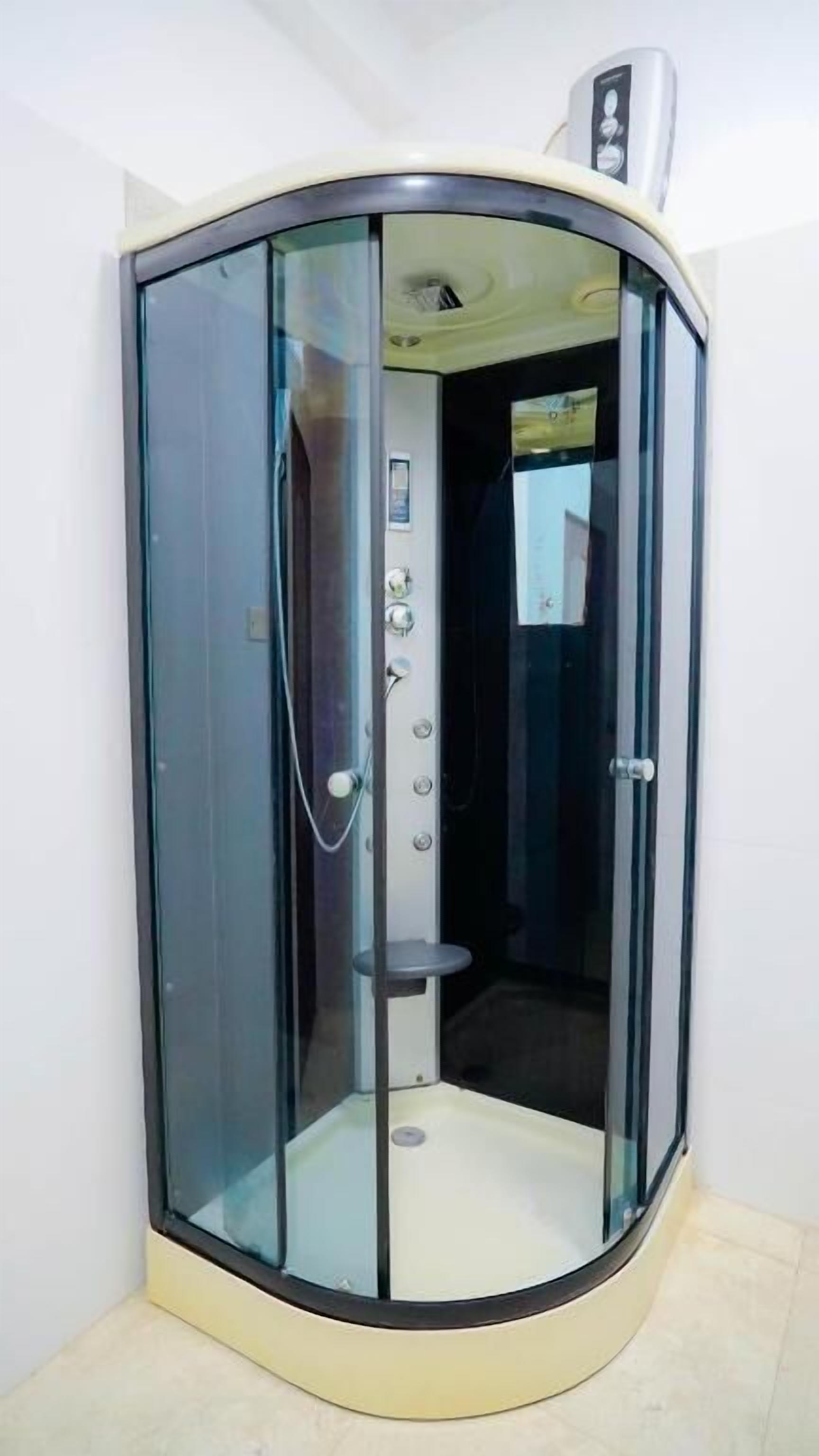 A glass-enclosed elevator with a control panel and a small platform.