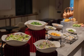 A buffet setup with various dishes on a marble counter. - National Music Hotel (Beijing)