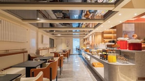 Un restaurante moderno con una barra larga, zona de estar y vistas a la calle.