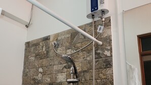 A shower with a stone wall, a control panel, and a door. - Double room 04 with 2 double beds, air conditioning, private bathroom (San Salvador)