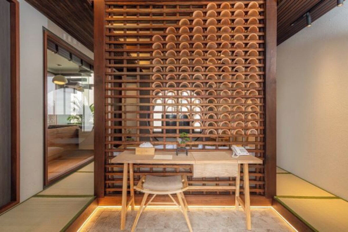 A modern room with a wooden partition, a desk, and a chair.