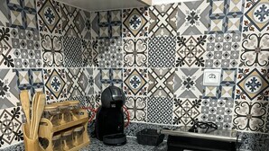 Une cuisine équipée d’une cuisinière à gaz, d’une machine à café et d’un étagère à épices.