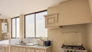 A kitchen with a stove, oven, and large windows.