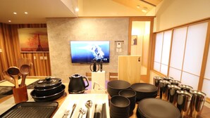 Un espace repas équipé d’un téléviseur, d’ustensiles de cuisine et décoré dans un style traditionnel.