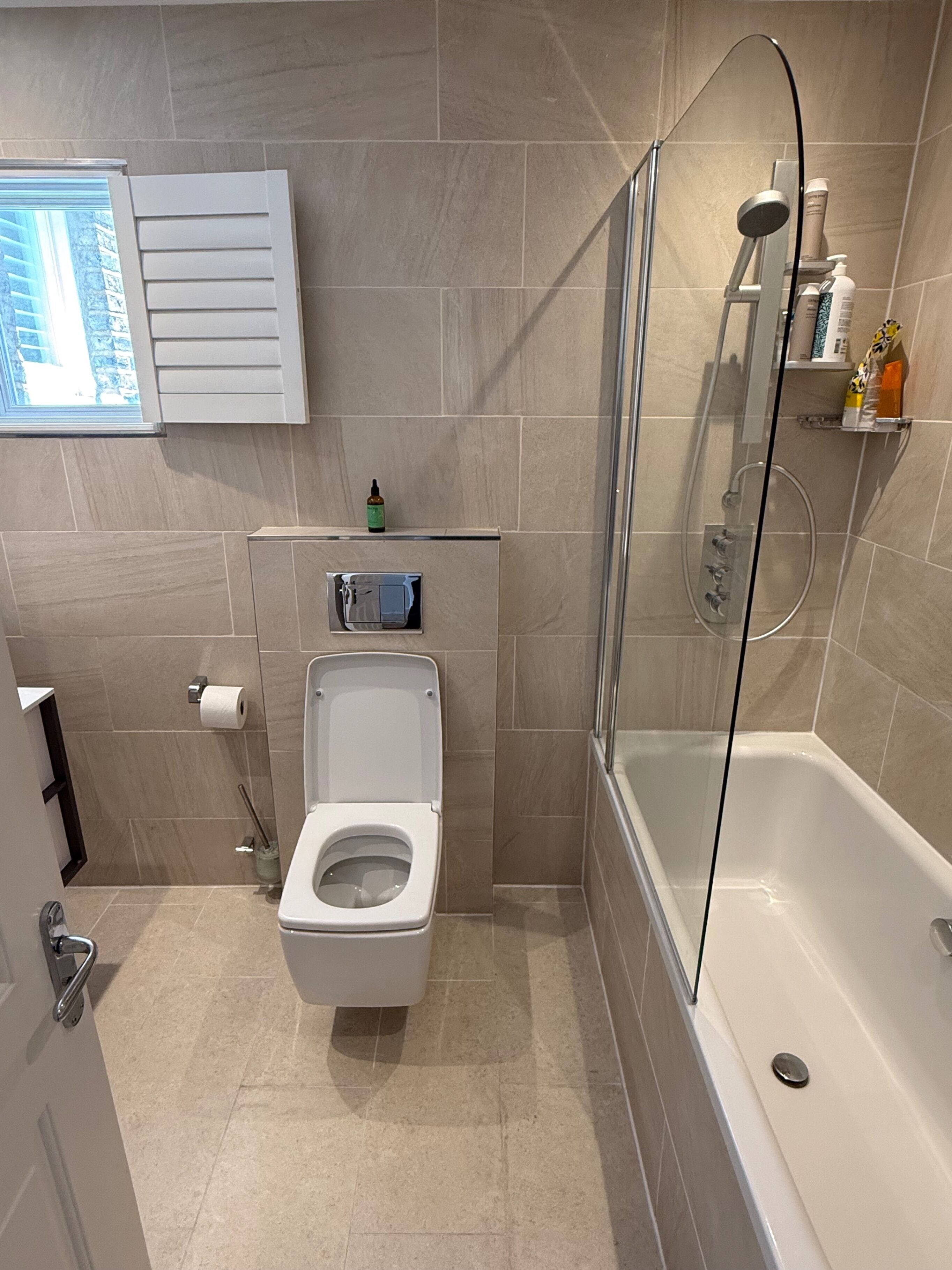 A modern bathroom with a toilet, shower, and bathtub.