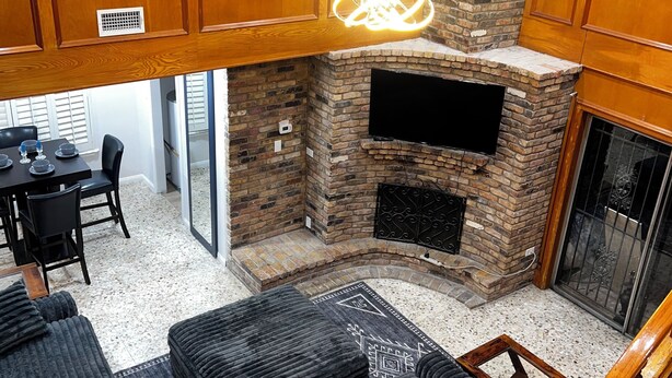 A modern living room with a stone fireplace, wooden cabinets, and a black leather sofa. - Spacious 5-bedroom house with AC, WiFi in awesome Houston (Houston)