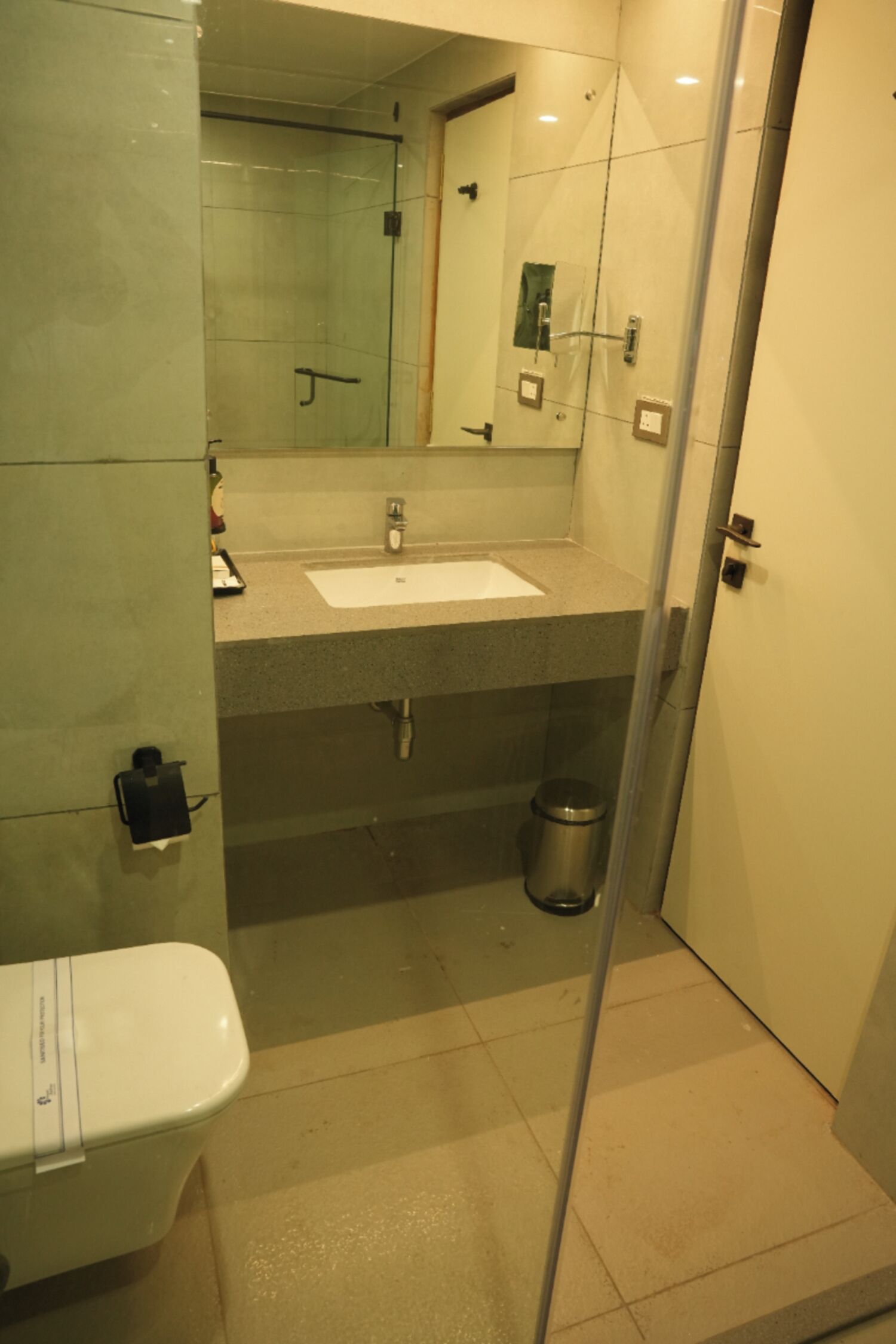 A bathroom with a sink, mirror, toilet, and shower.