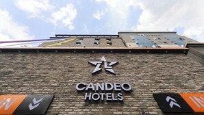 Exterior del hotel Candeo con un llamativo logo con una estrella y el nombre del hotel.