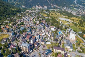 An aerial view of a town with residential buildings, a roundabout, and a large circular building.