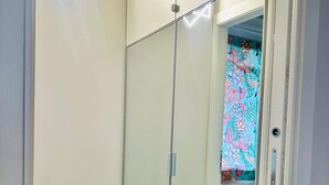 A room with a mirrored wardrobe, a wooden floor, and a door leading to a bathroom with a floral shower curtain. - Residence at Passetto historic center (Verona)