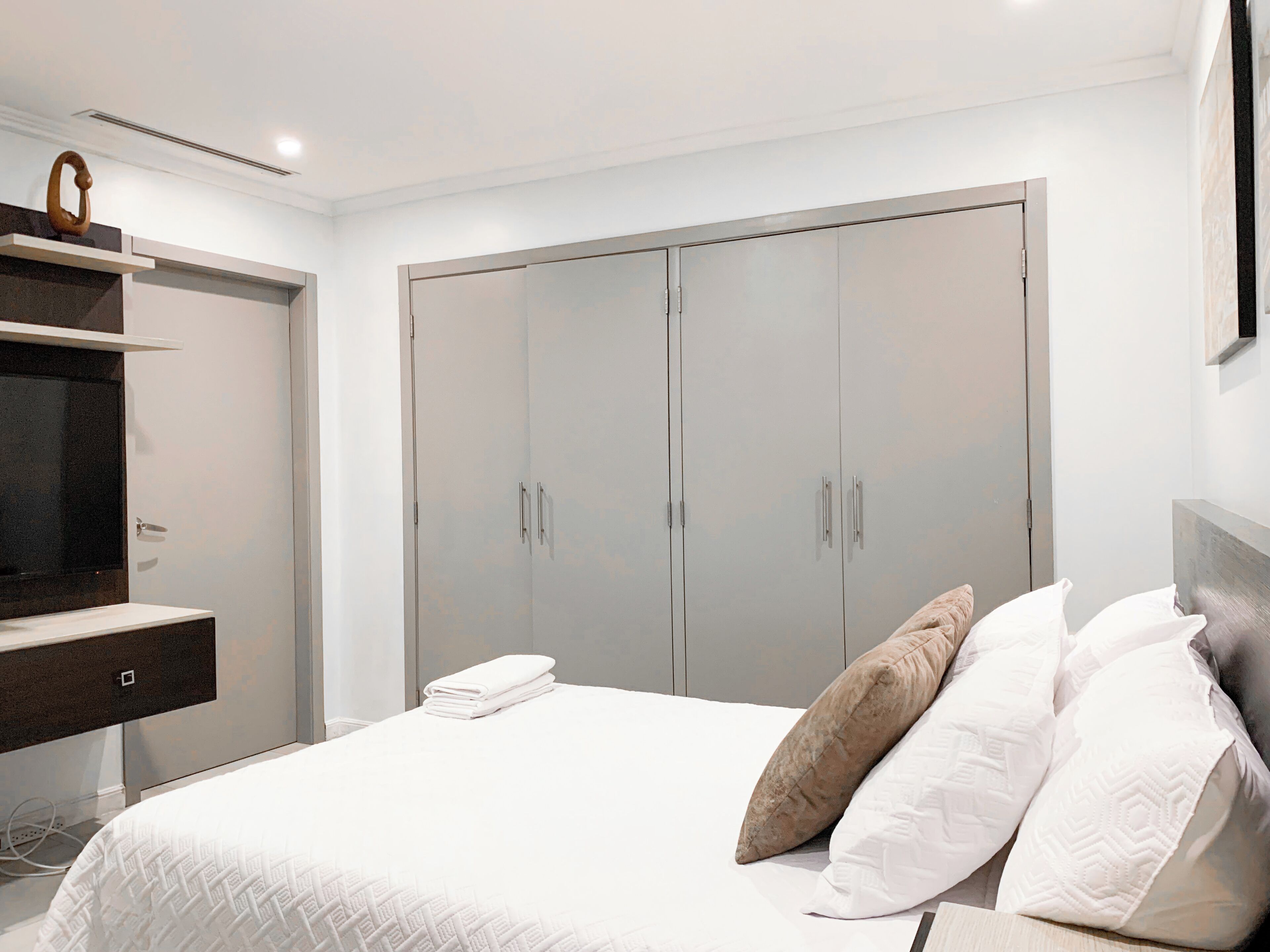 Un dormitorio con cama, armario y tocador.