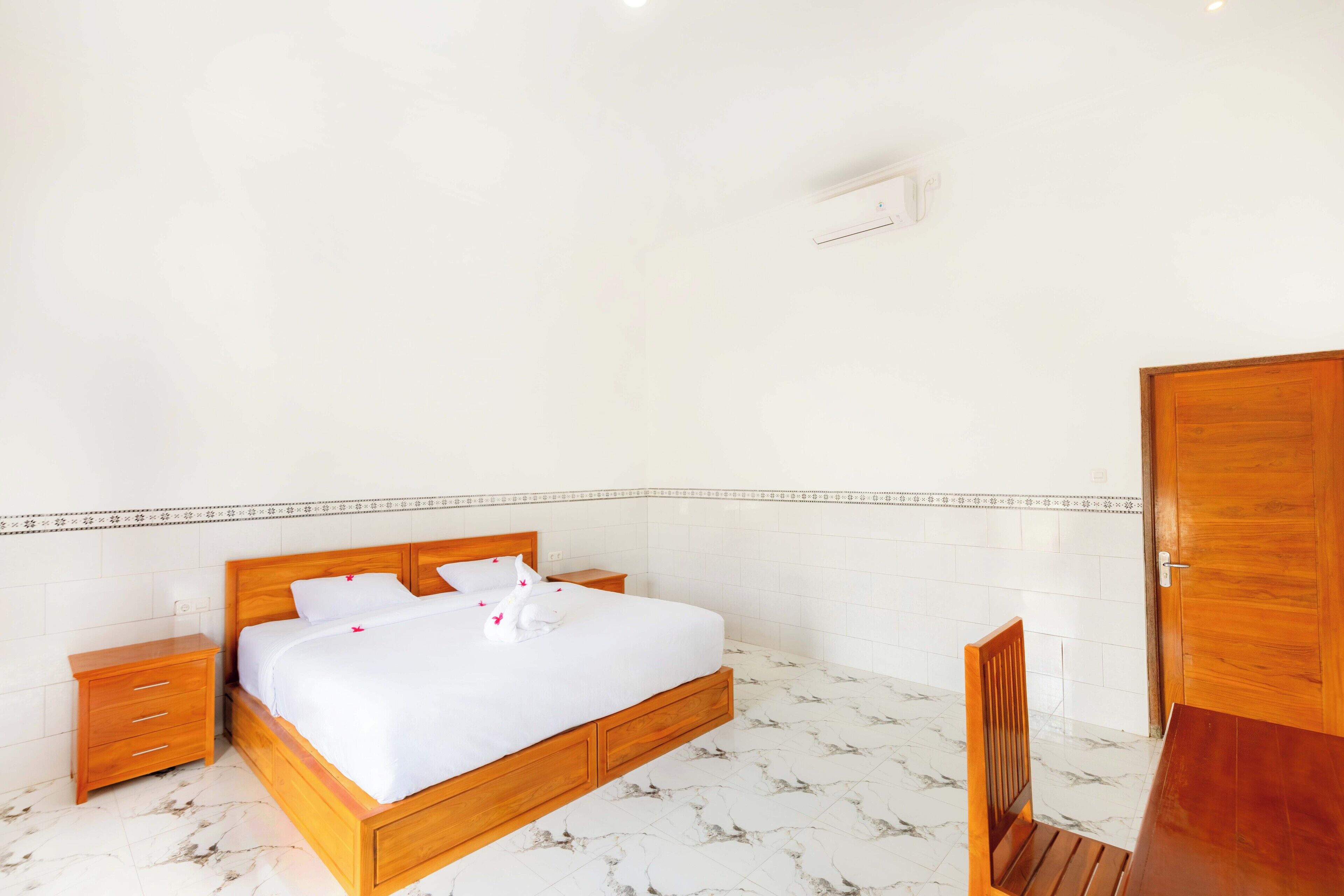 A bedroom with a wooden bed, white walls, and a tiled floor.