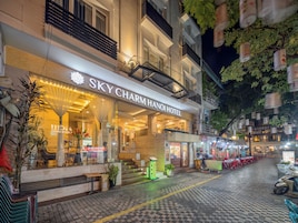 A hotel with a modern facade, a visible entrance, and outdoor seating area.