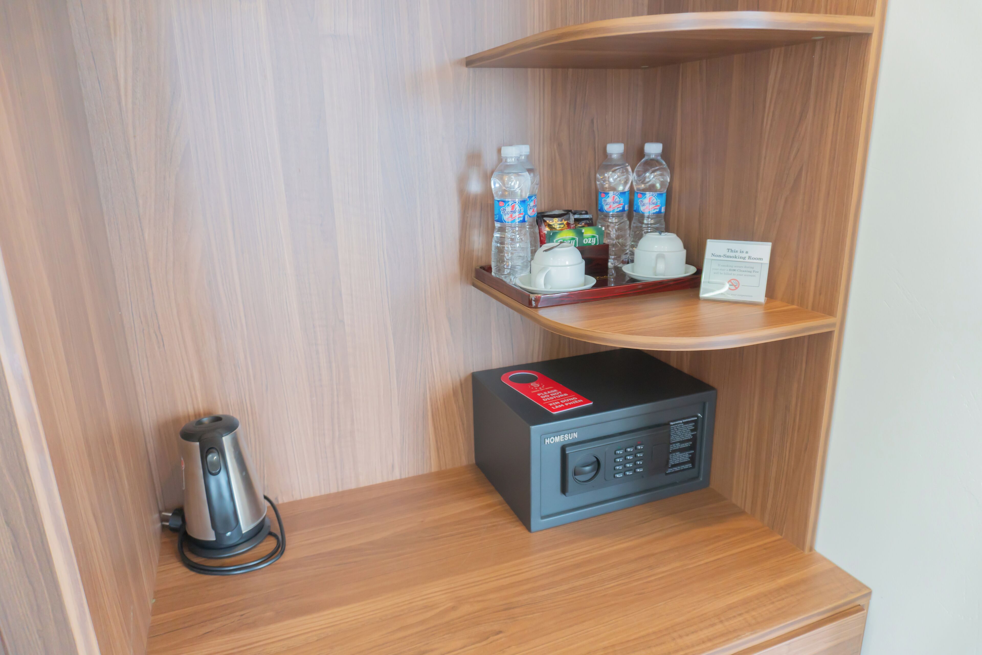 A compact kitchenette with a coffee maker, water bottles, and a microwave.