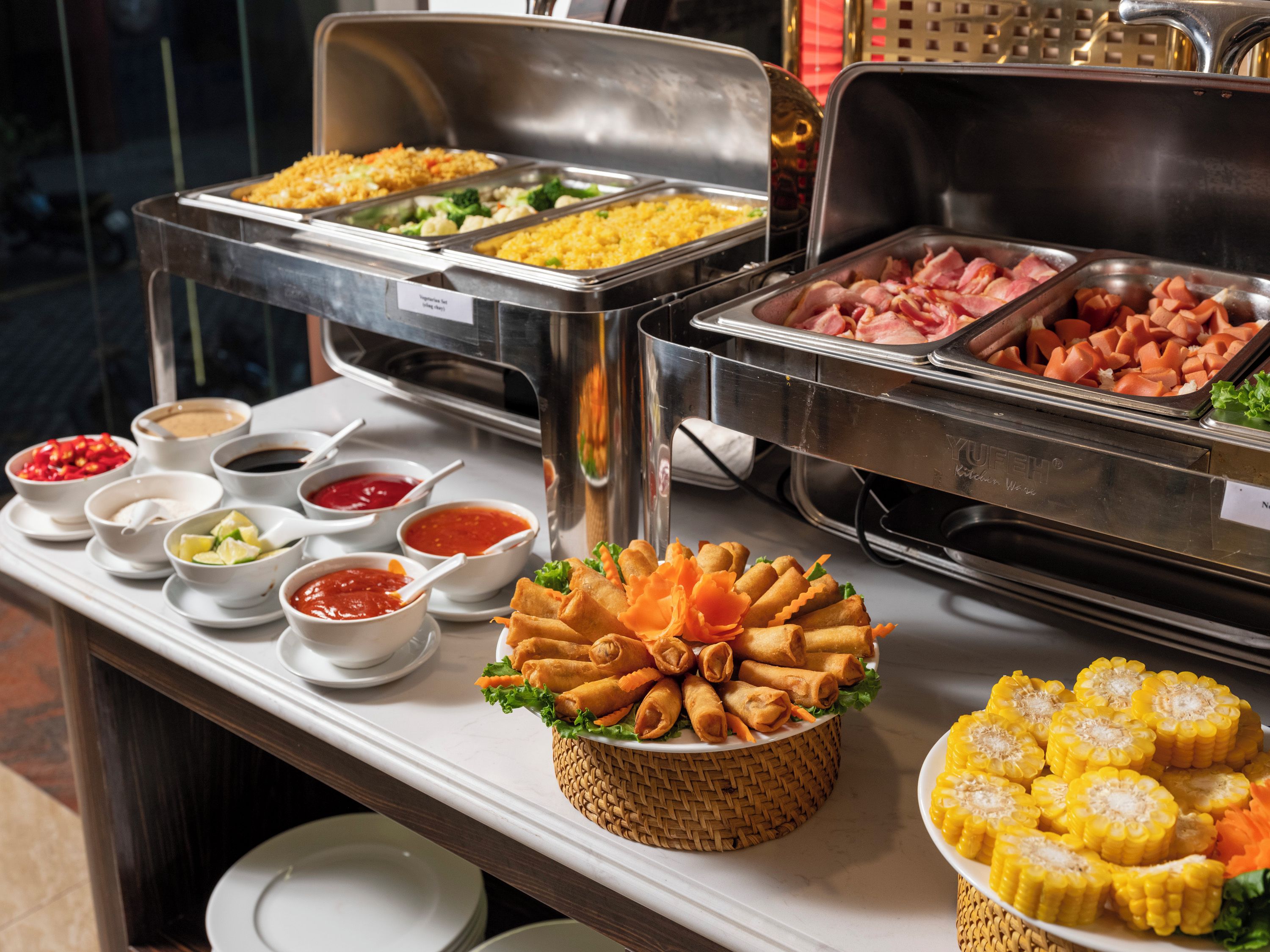 A buffet with various food items and condiments.