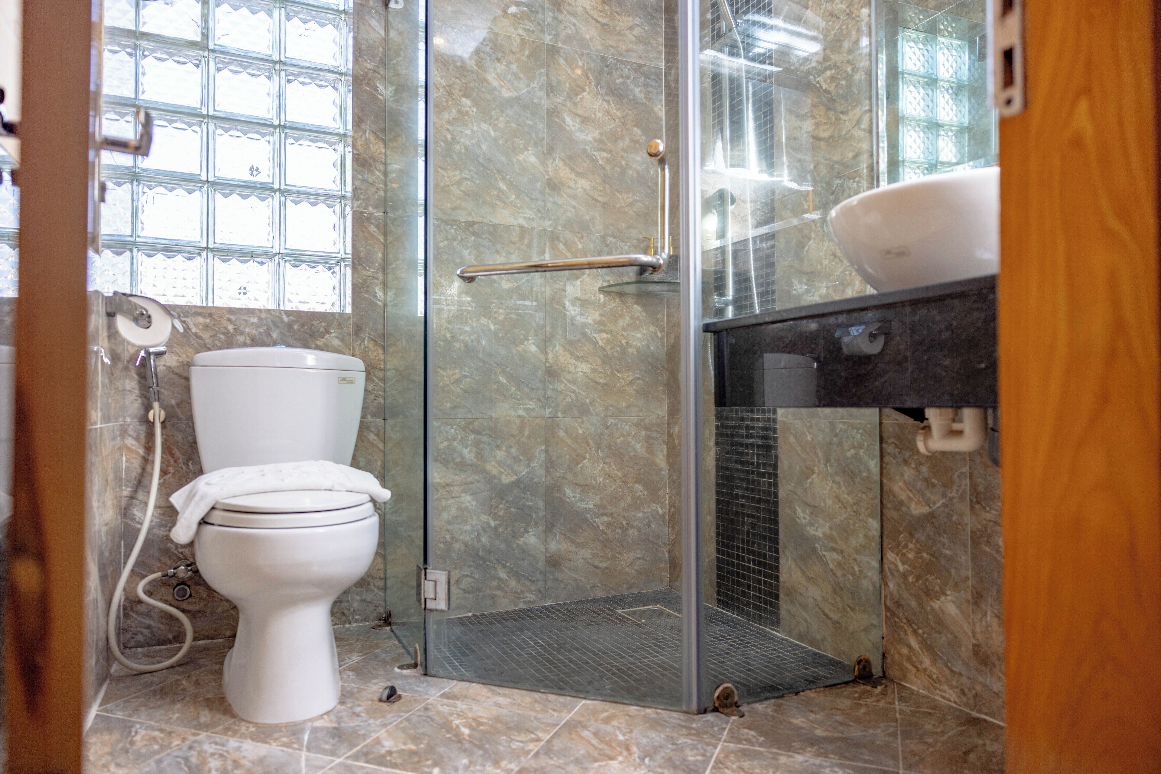 Ein Badezimmer mit Toilette, Duschkabine und Waschbecken.