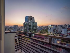A cityscape at dusk with a prominent hotel labeled 'OPEs' and a 'HABIFOTEL' across the street.