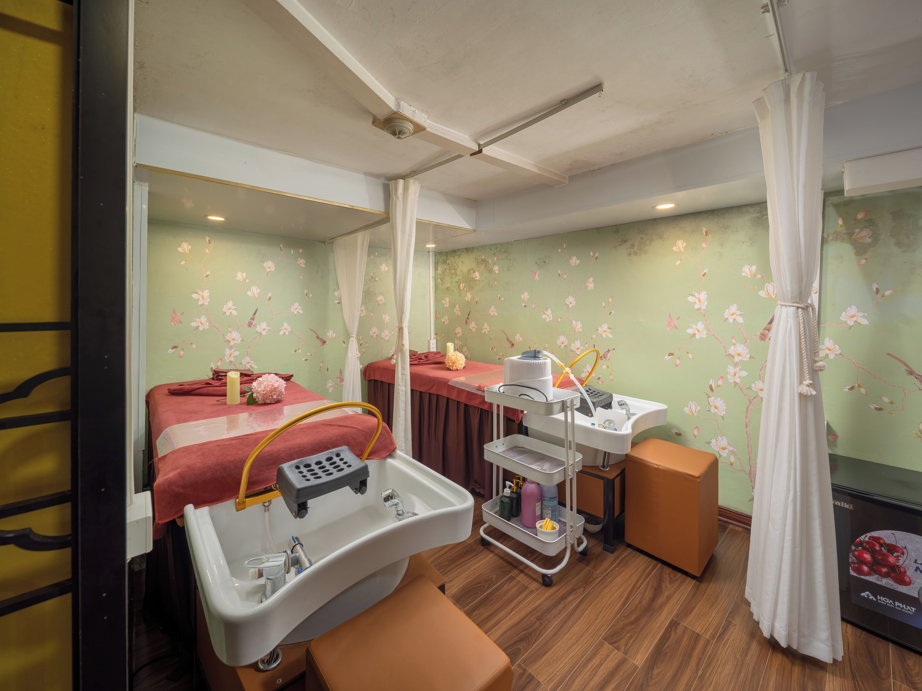 A hotel room with a bed, a vanity with a mirror, a sink, and a small table with toiletries.
