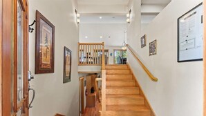 A wooden staircase with a handrail, leading to an upper level.