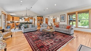 A spacious living area with a large rug, two sofas, and a coffee table.