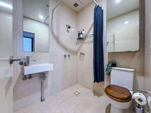 Une salle de bain moderne équipée d’une douche, de toilettes et d’un lavabo.