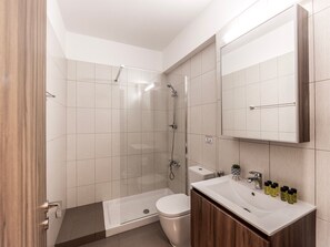 A modern bathroom with a shower, toilet, and sink. - 2bedroom apartment in kapparis Mythical AL04 (Kapparis)
