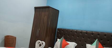 Un dormitorio con una cama, un armario y una silla.