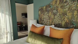 Une chambre d’hôtel équipée d’un lit, d’oreillers, d’une télévision et d’une tête de lit décorative.