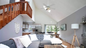 A modern living room with a grey sofa, wooden staircase, and a ceiling fan. - Your Best Vacation is waiting at the Sage Chalet - Close to Kalahari & Camelback (Long Pond)