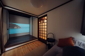 A modern room with a sliding door leading to a balcony, a bed with a pillow, a small table, and a view of the sea. - MIZUSHIMA OLD HOUSE｜Family and friends｜Nostalgic house｜98 ㎡｜Parking lot｜Bikan Historical Quarter 20 min.｜Seto Ohashi Bridge 30 min.｜Naoshima (倉敷市水島西弥生町)