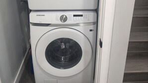 A Samsung front-loading washer and dryer stacked in a narrow space. - Home in Northwest Calgary. (Calgary)