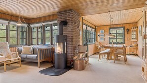 A cozy interior with a fireplace, wooden furniture, and large windows. - Summerhouse in peaceful surroundings (Pandrup)