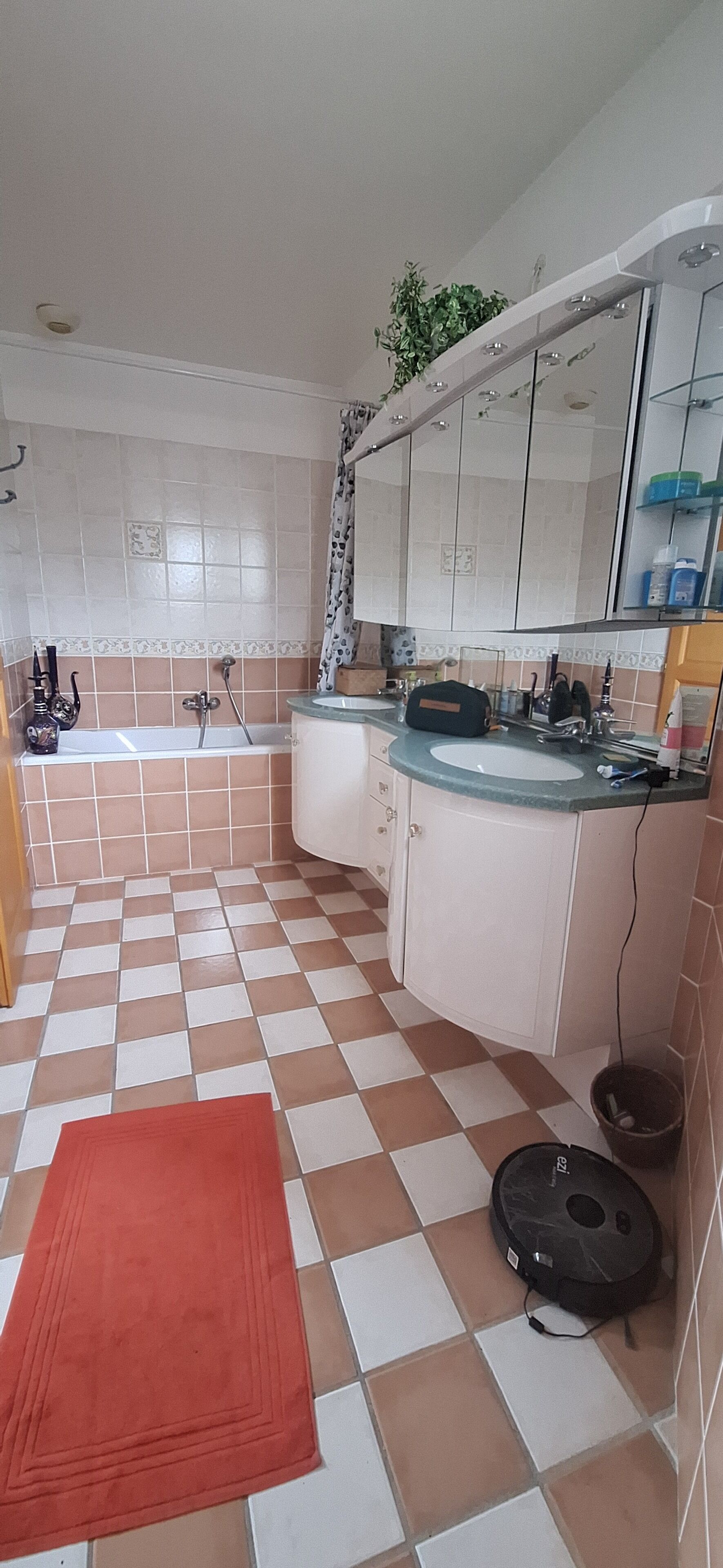 A bathroom with a bathtub, a sink, and a mirror.