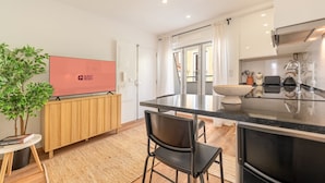 A modern kitchen with a central island, a built-in oven, and a large window. - GuestReady – Timeless Lisbon Retreat (Lisbon)