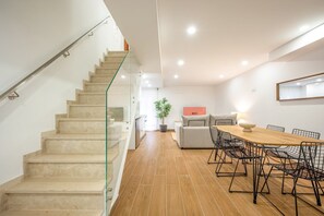 Un intérieur moderne comprenant un escalier, un coin repas et un espace de vie.