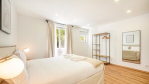 Camera moderna con un letto grande, una lampada da comodino, un armadio e uno specchio a parete.