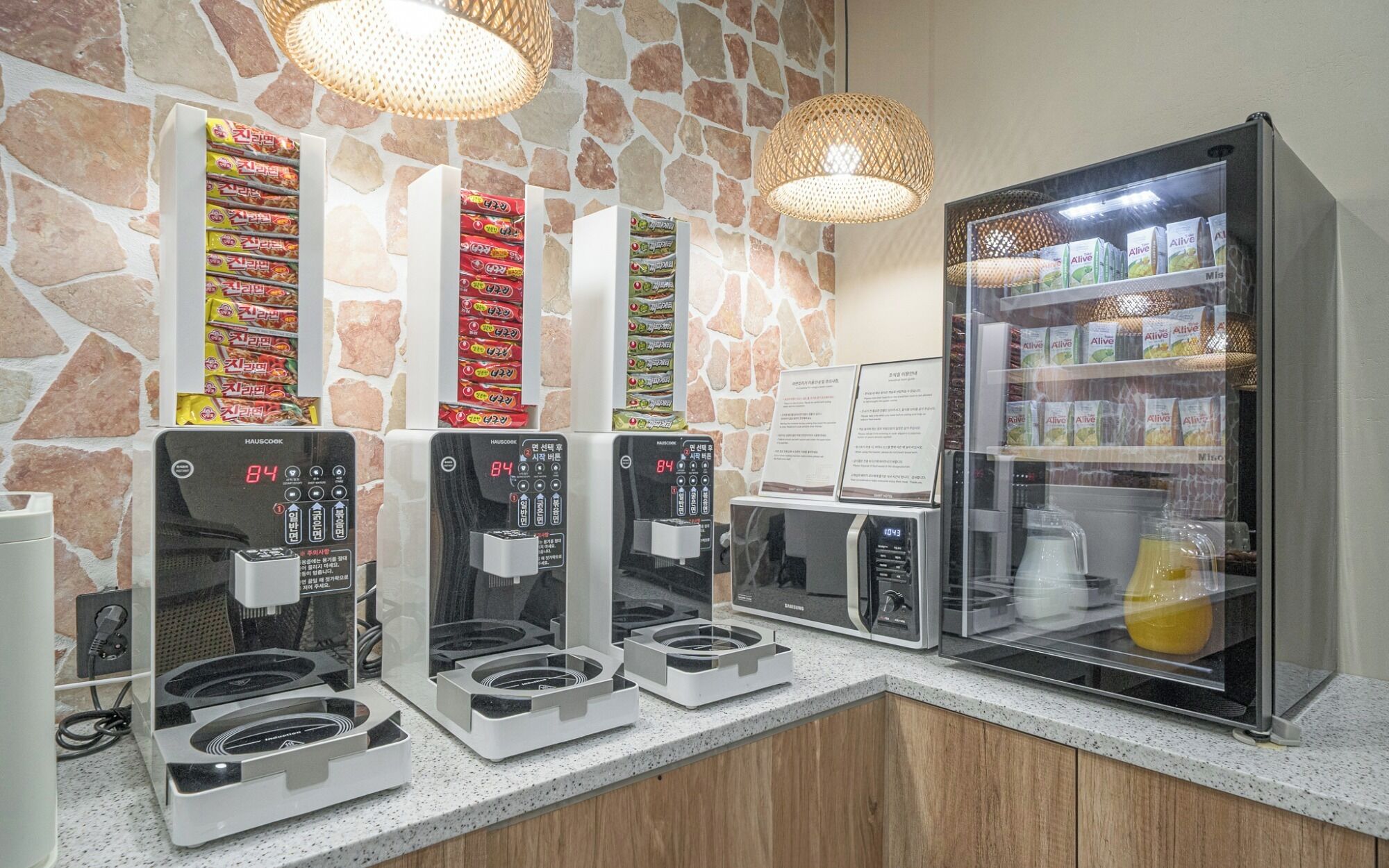 A self-service coffee station with multiple coffee machines and a refrigerator stocked with beverages.