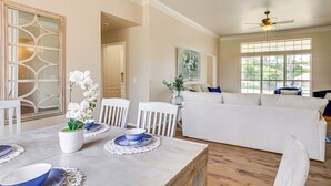 A spacious living area with a white sofa, dining table with blue plates, and a ceiling fan. - < 1 Mi to Oak Tree National: Cozy Getaway! (Edmond)