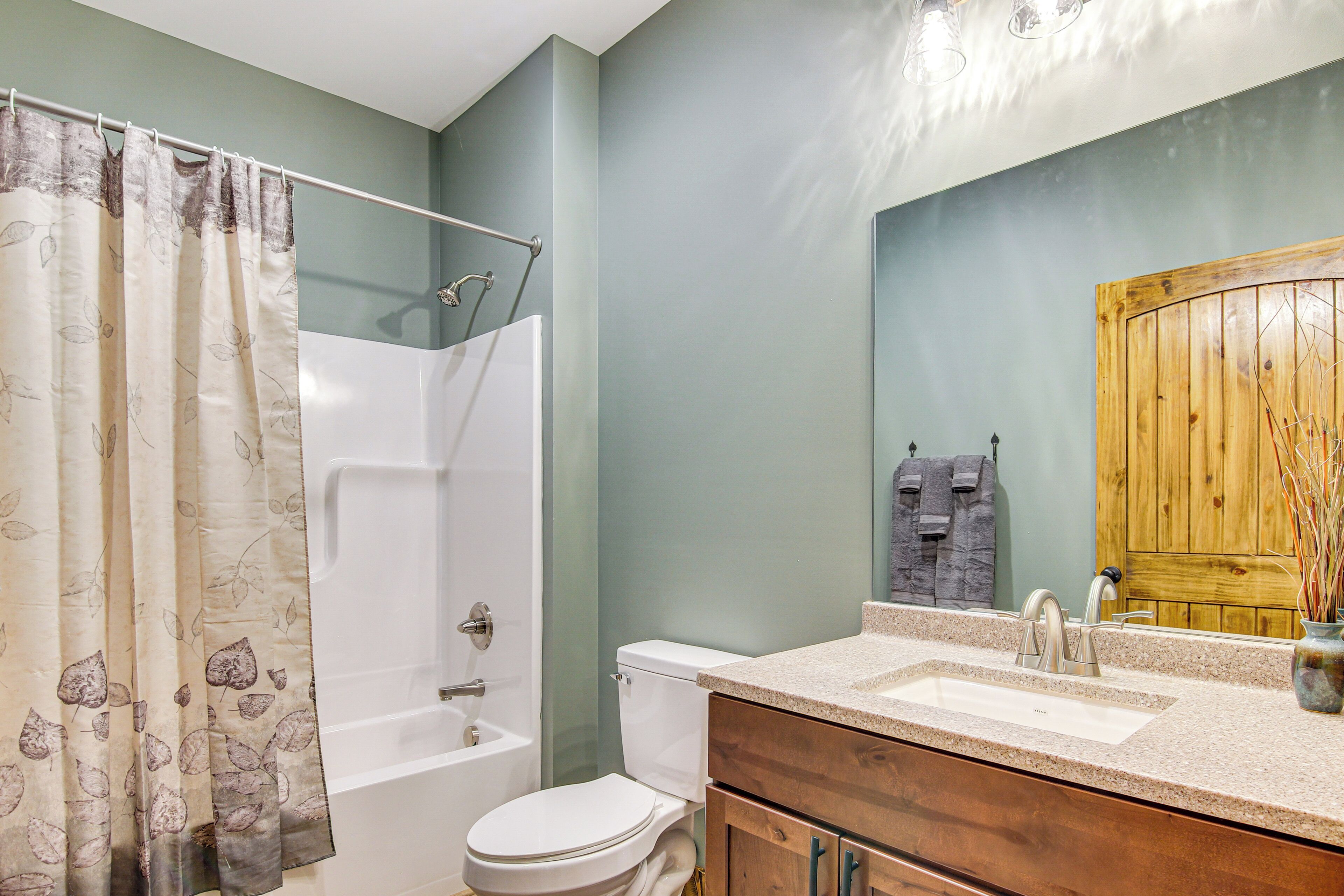 A bathroom with a bathtub, toilet, and sink.