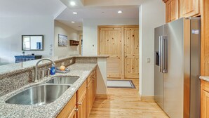 A kitchen with granite countertops, stainless steel sinks, wooden cabinets, and a stainless steel refrigerator. - 2 Mi to Angel Fire Resort: Luxury Condo w/ Balcony (Angel Fire)