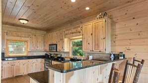 Une cuisine spacieuse avec des meubles en bois, un plan de travail en granit et un îlot central.