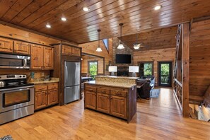 A spacious kitchen with wooden cabinets, stainless steel appliances, and a large island. - EZ Come EZ Geaux - Stunning Mtn Views - Hot Tub (Blue Ridge)